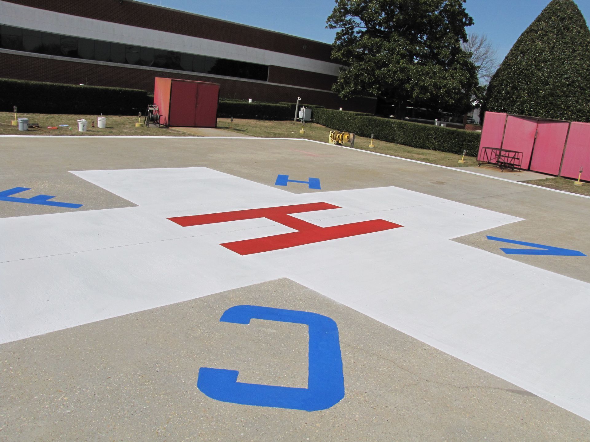 Outdoor school play area with colorful painted letters and arrows on concrete court