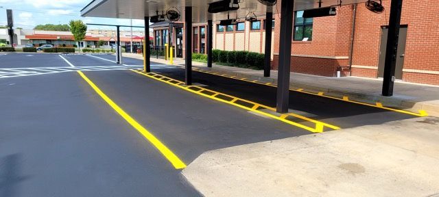 Marked accessible parking area beside a brick building with bright yellow curb and line markings