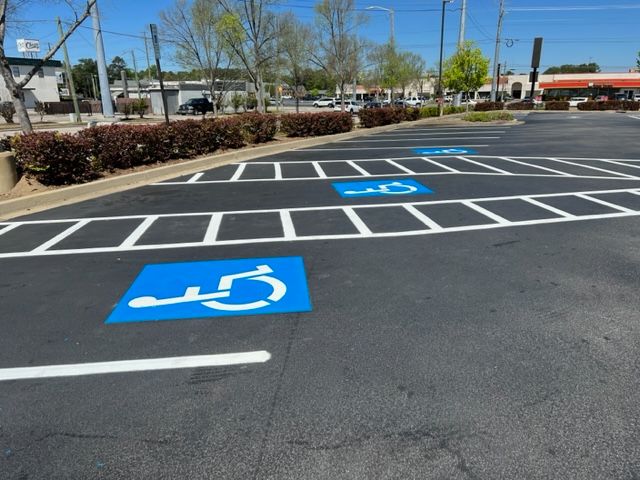 Accessible parking spaces painted blue and white in a parking lot on a sunny day in Raleigh, NC