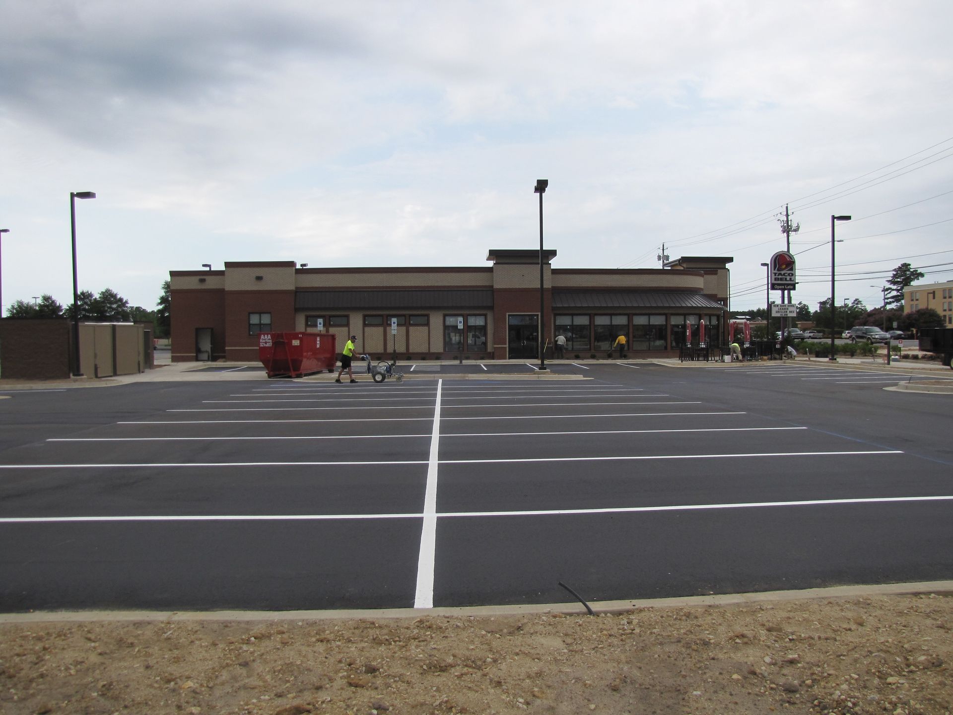 Empty parking lot in front of a low commercial building under a cloudy sky