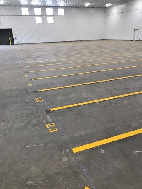 Empty indoor warehouse with marked parking spaces on a concrete floor