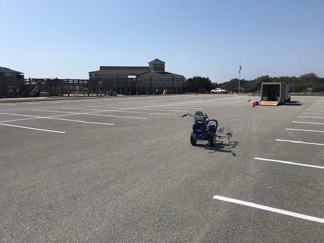 Blue mobility scooter in an empty parking lot near a building on a clear day