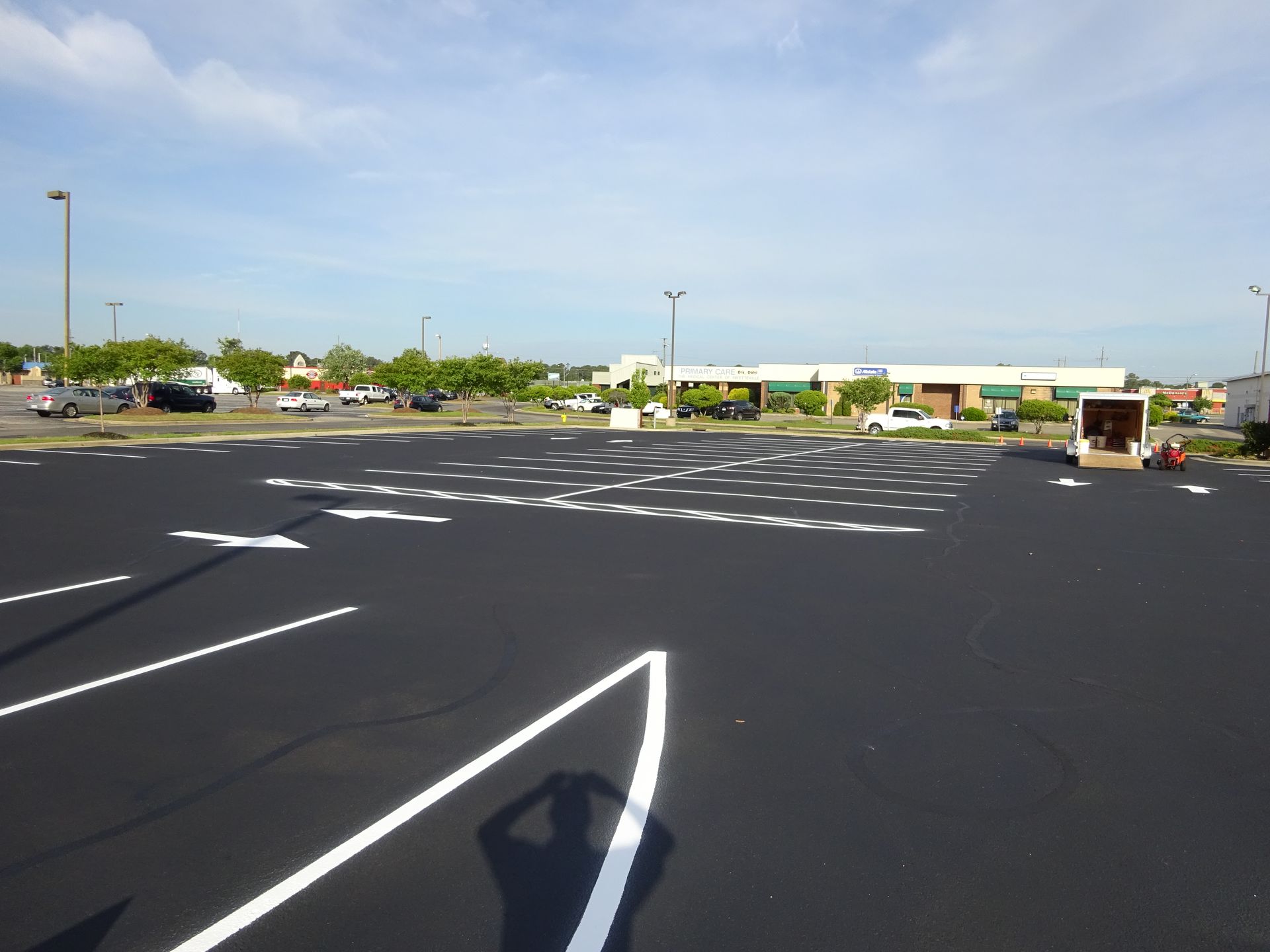 Empty parking lot with fresh white lane markings under a clear sky