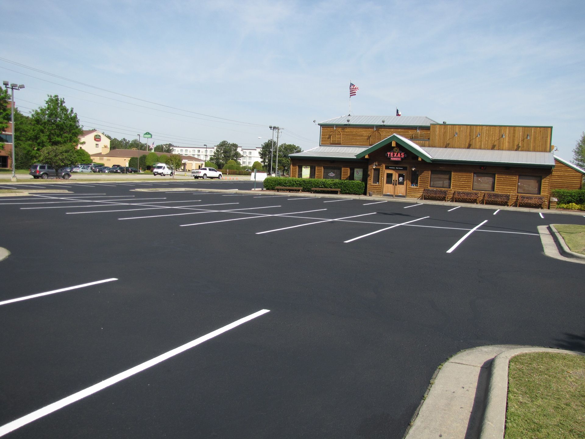 Empty parking lot beside a rustic restaurant on a sunny day