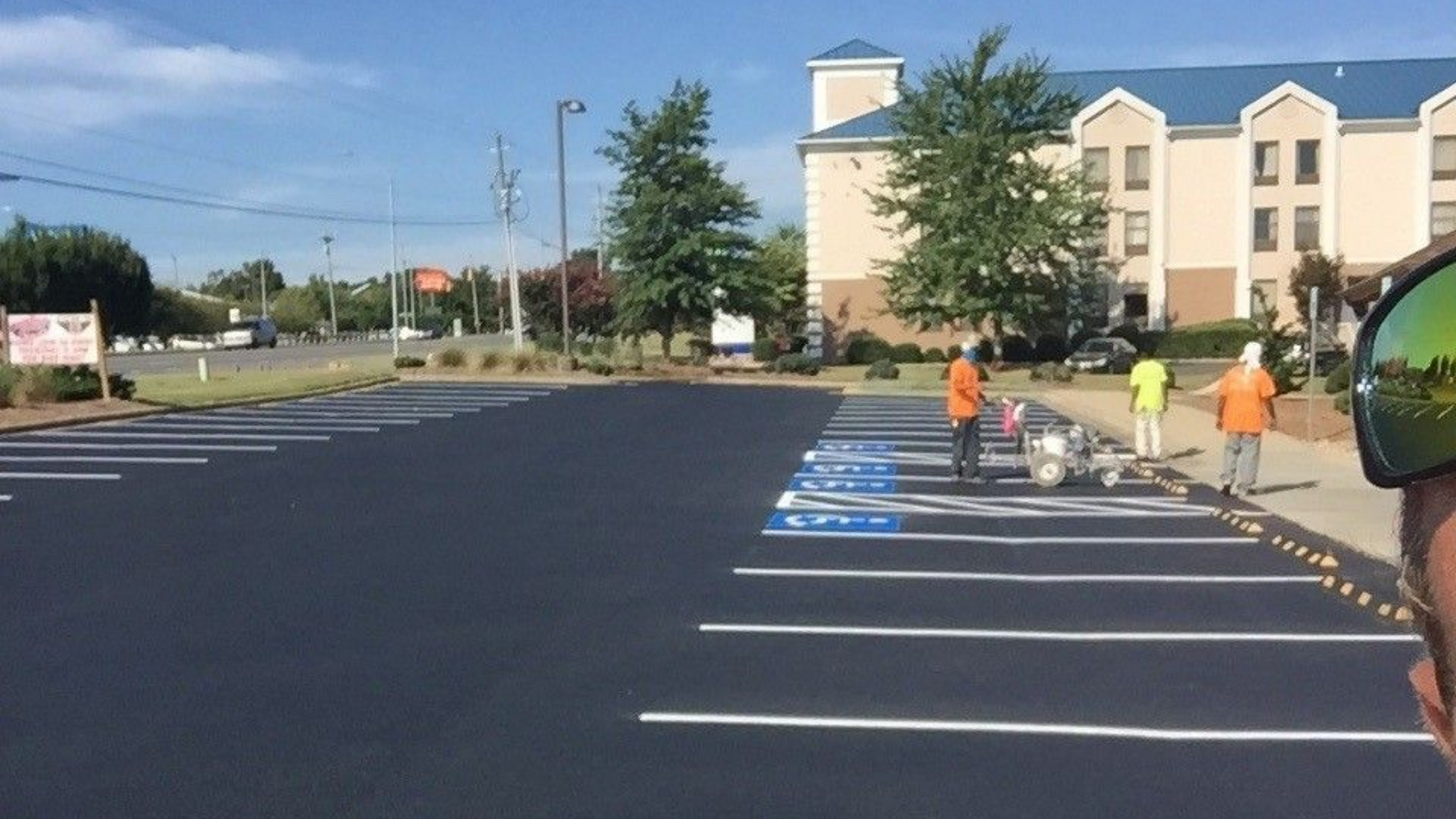 Empty parking lot with accessible parking spaces and people near a building entrance in Raleigh, NC
