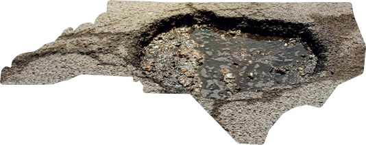 An outline of the state of North Carolina shaped like a pothole with cracked, grey pavement and pooled water.