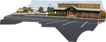 A wooden restaurant building with a large paved parking lot in front, cut out to resemble the shape of North Carolina.