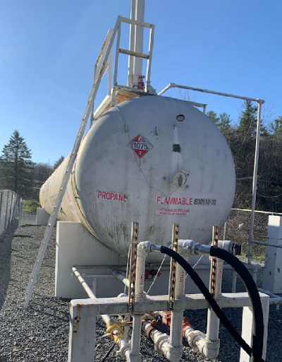 A weathered propane tank labeled 