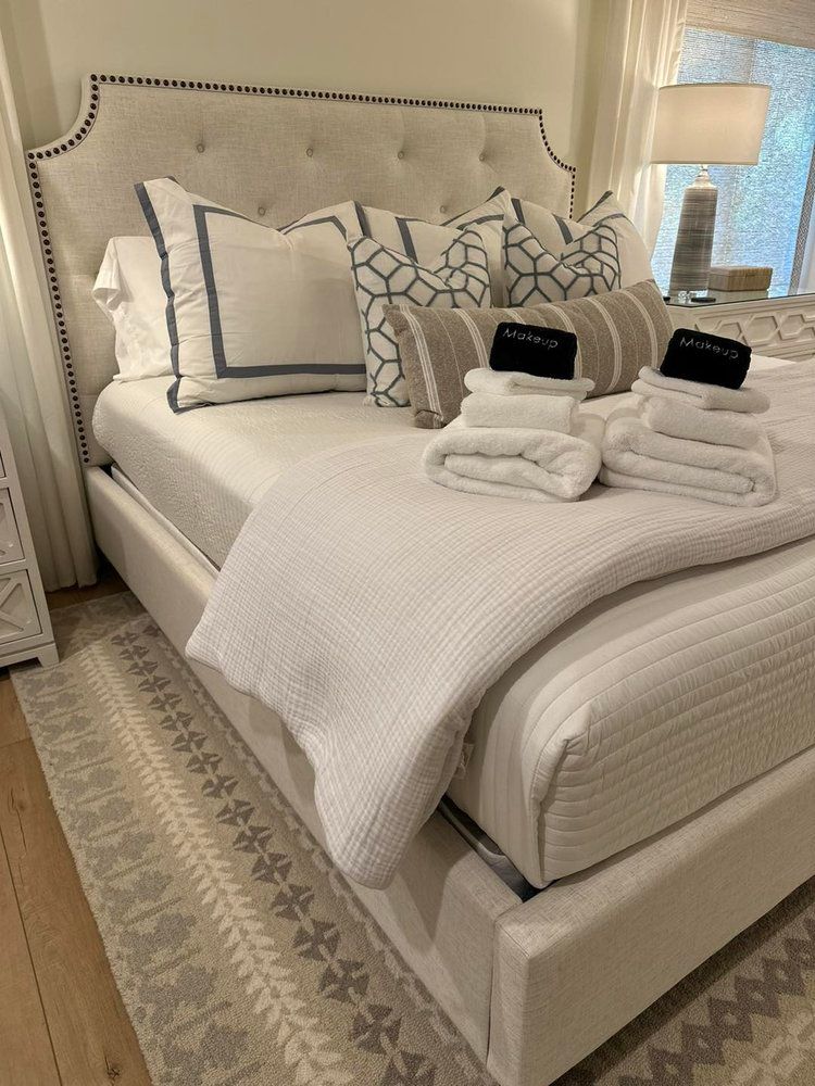 A bed with white sheets and pillows in a bedroom.