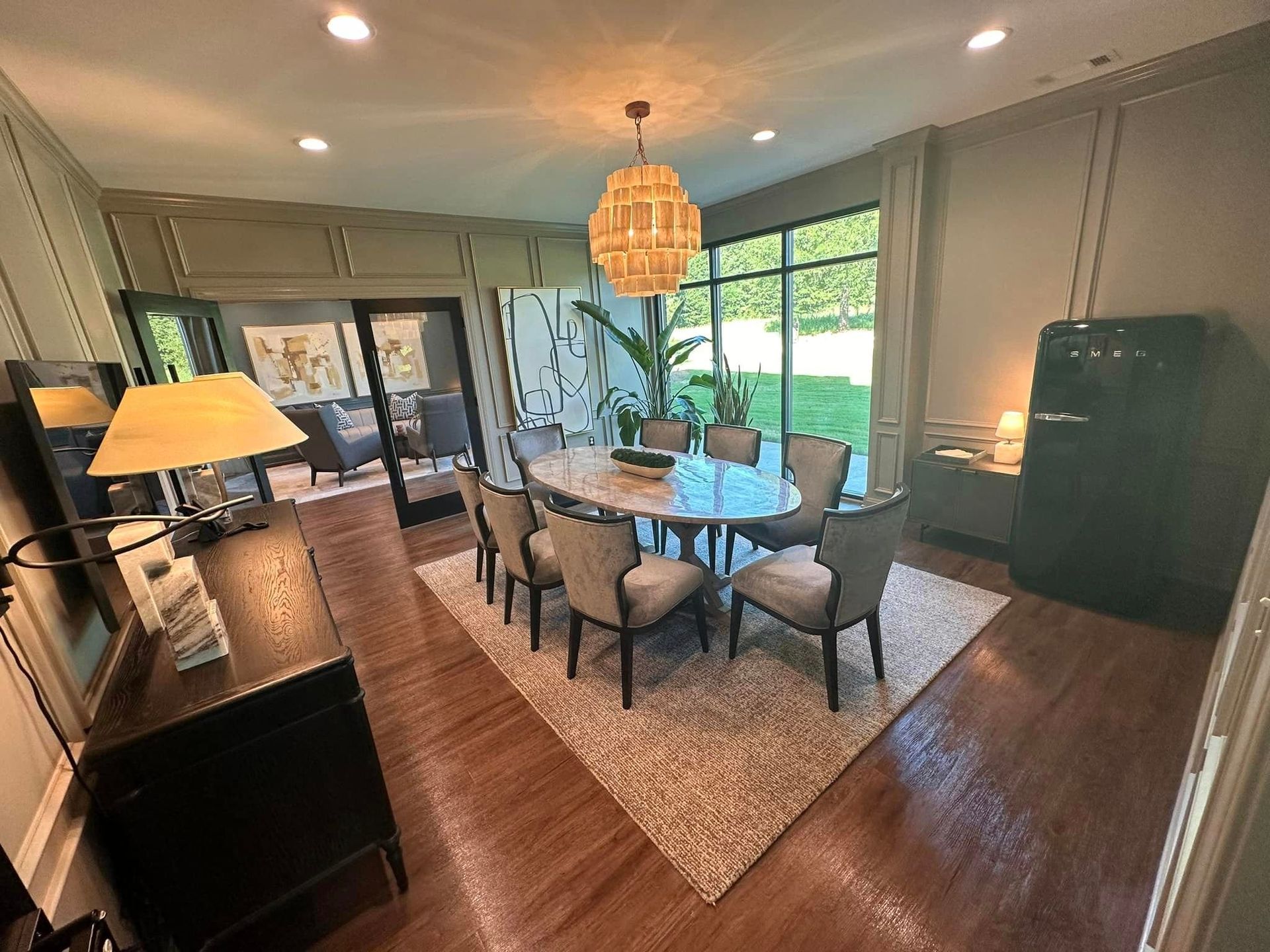 A dining room with a table and chairs and a large window.