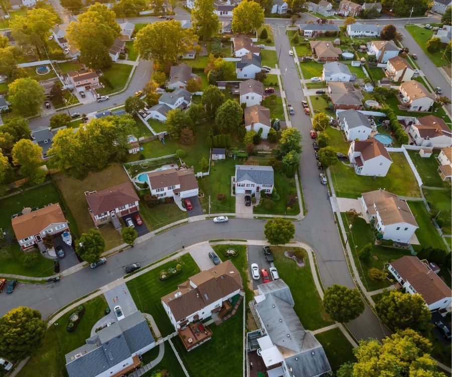 An aerial view of a residential neighborhood with lots of houses and trees.