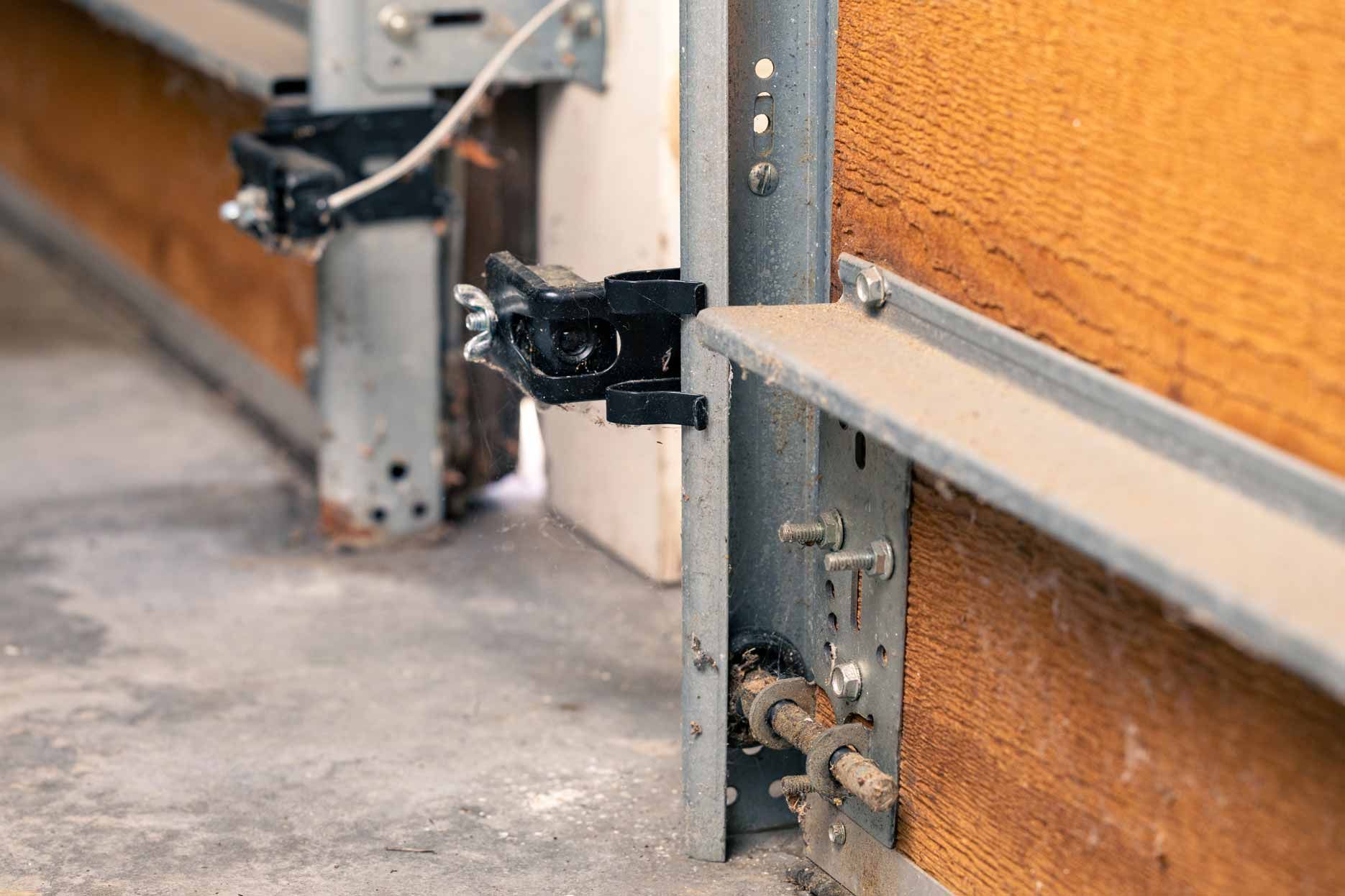 Close-up of metal clamps attached to a wooden wall and concrete floor