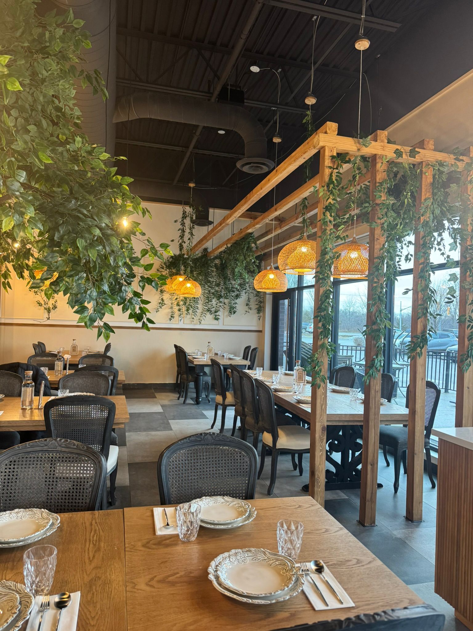 A restaurant with tables and chairs and a tree in the middle of the room.