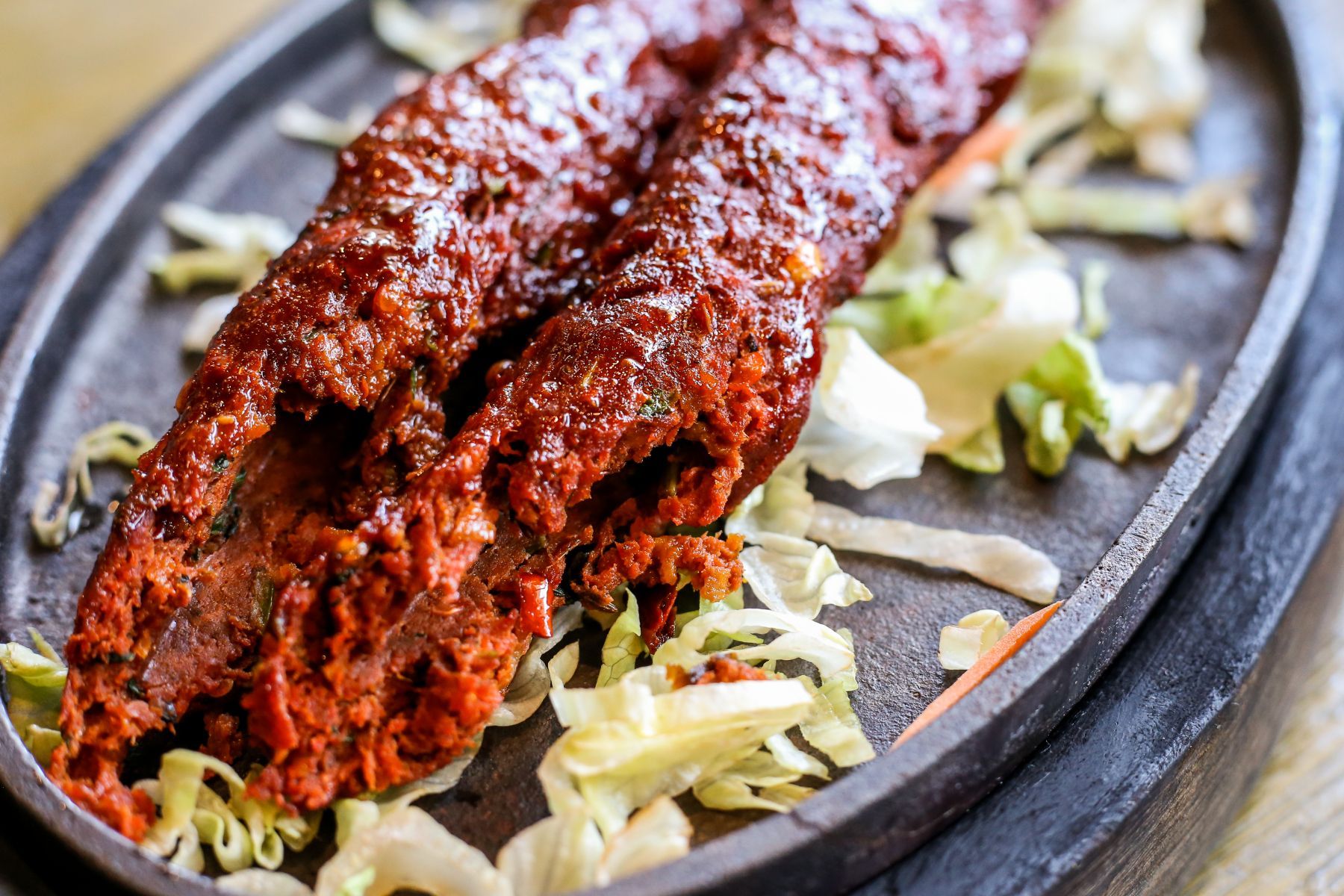 A close up of a plate of food with meat and vegetables on a table.