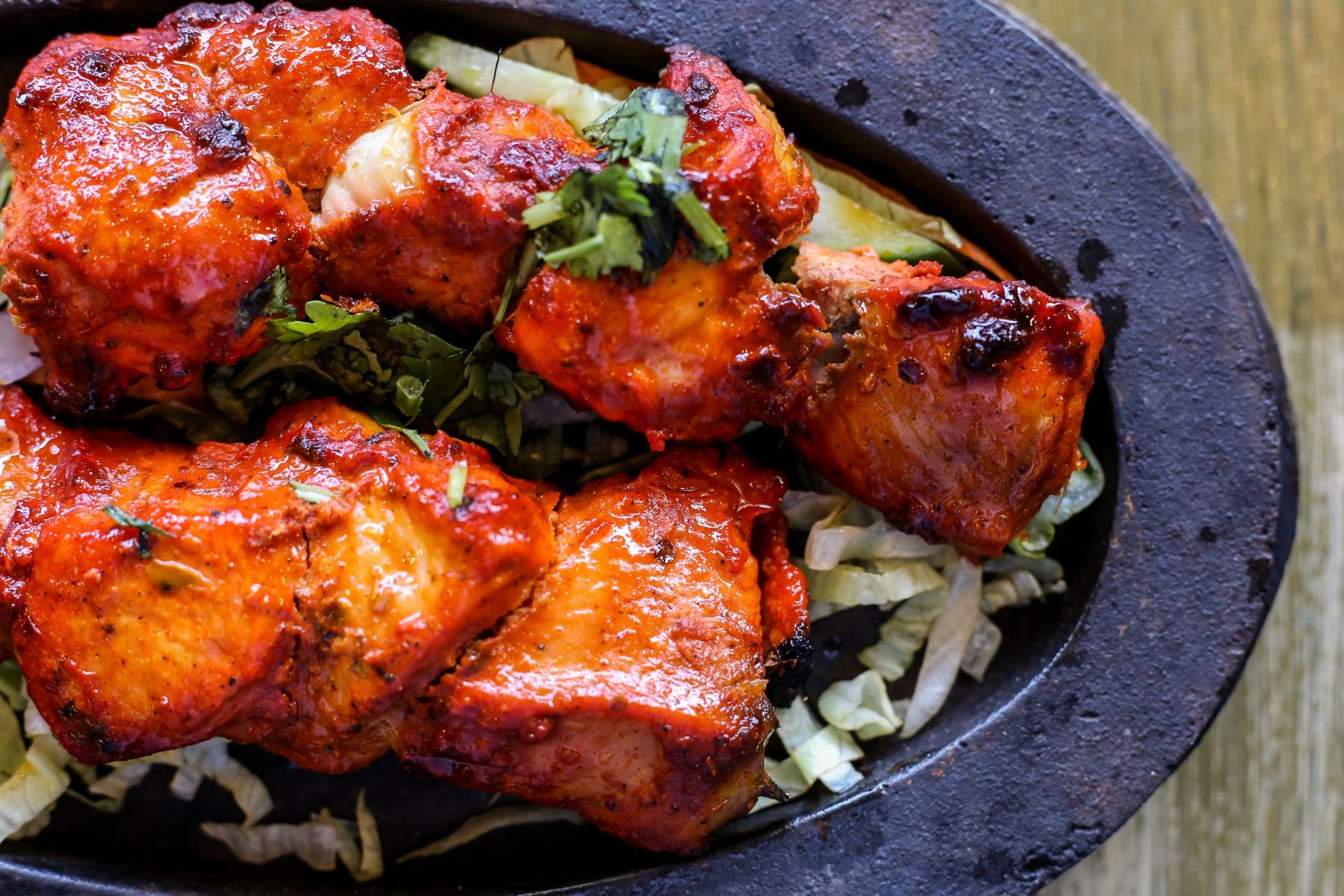A close up of a plate of food with meat and vegetables on a table.