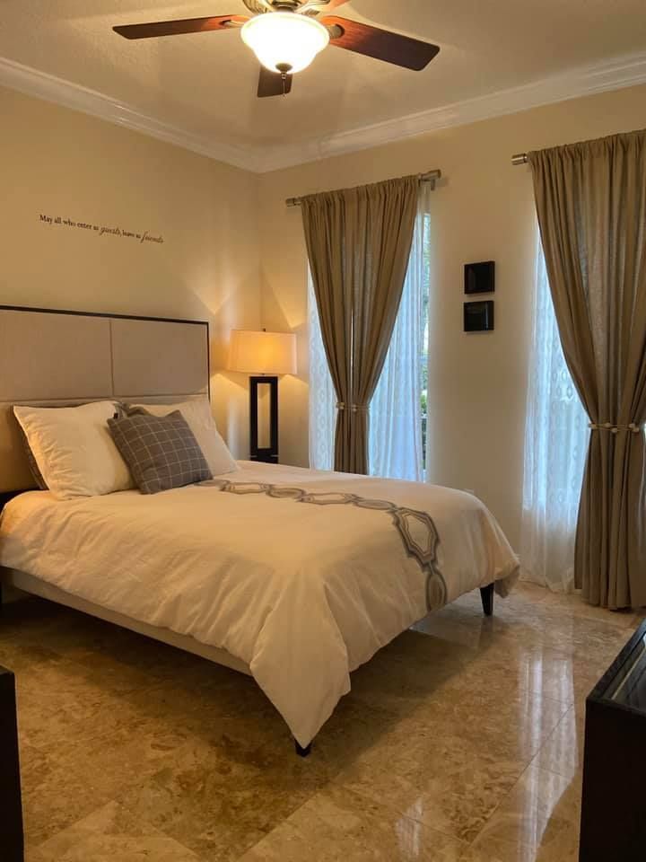 A bedroom with a bed and a ceiling fan
