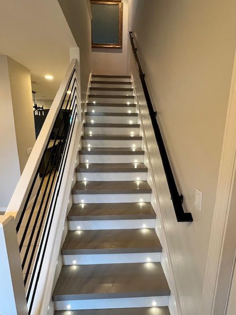 A set of stairs with lights on the steps in a house.