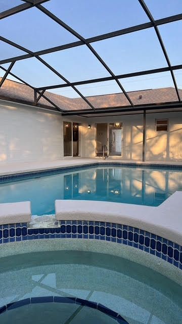 A swimming pool with a hot tub in front of it