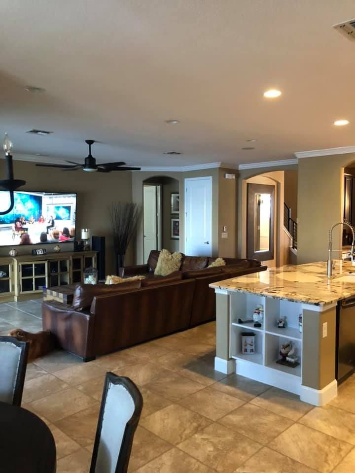 A living room with a couch , table , chairs and a television.