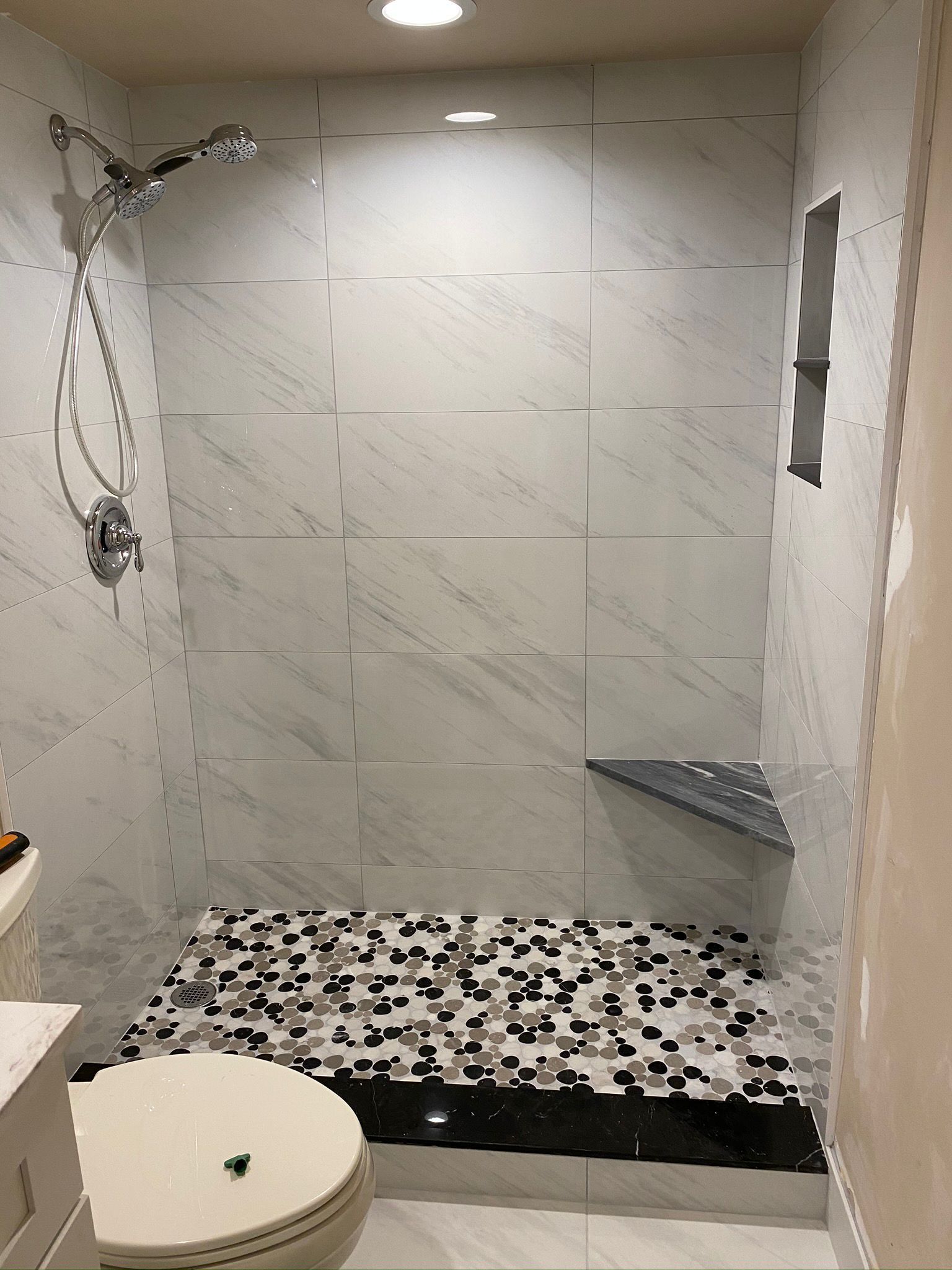 A bathroom in Palm Beach County with a walk in shower , toilet and sink.
