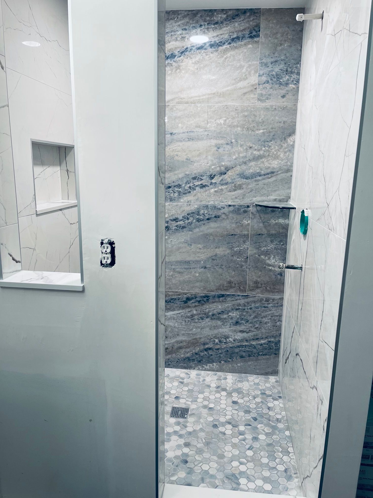 A bathroom in Palm Beach County, FL with a walk in shower and a marble wall.
