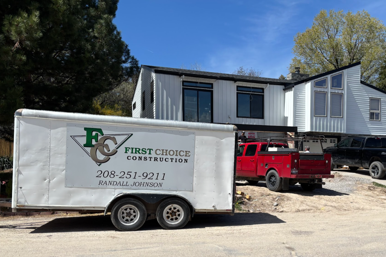 Construction trailer and red pickup truck in front of a house under renovation Remodelers pocatello idaho