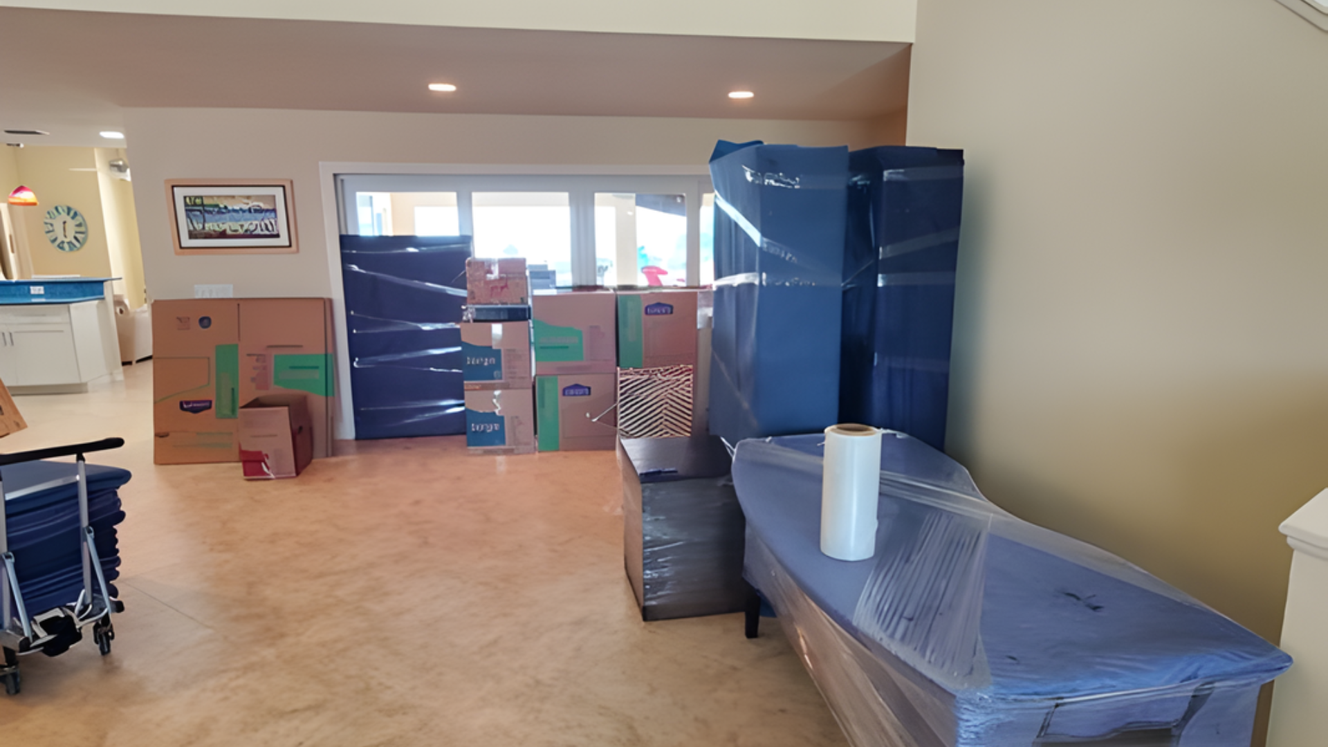 Sunlit moving boxes and lamps in a room, with a handwritten box labeled “kitchen with cake”