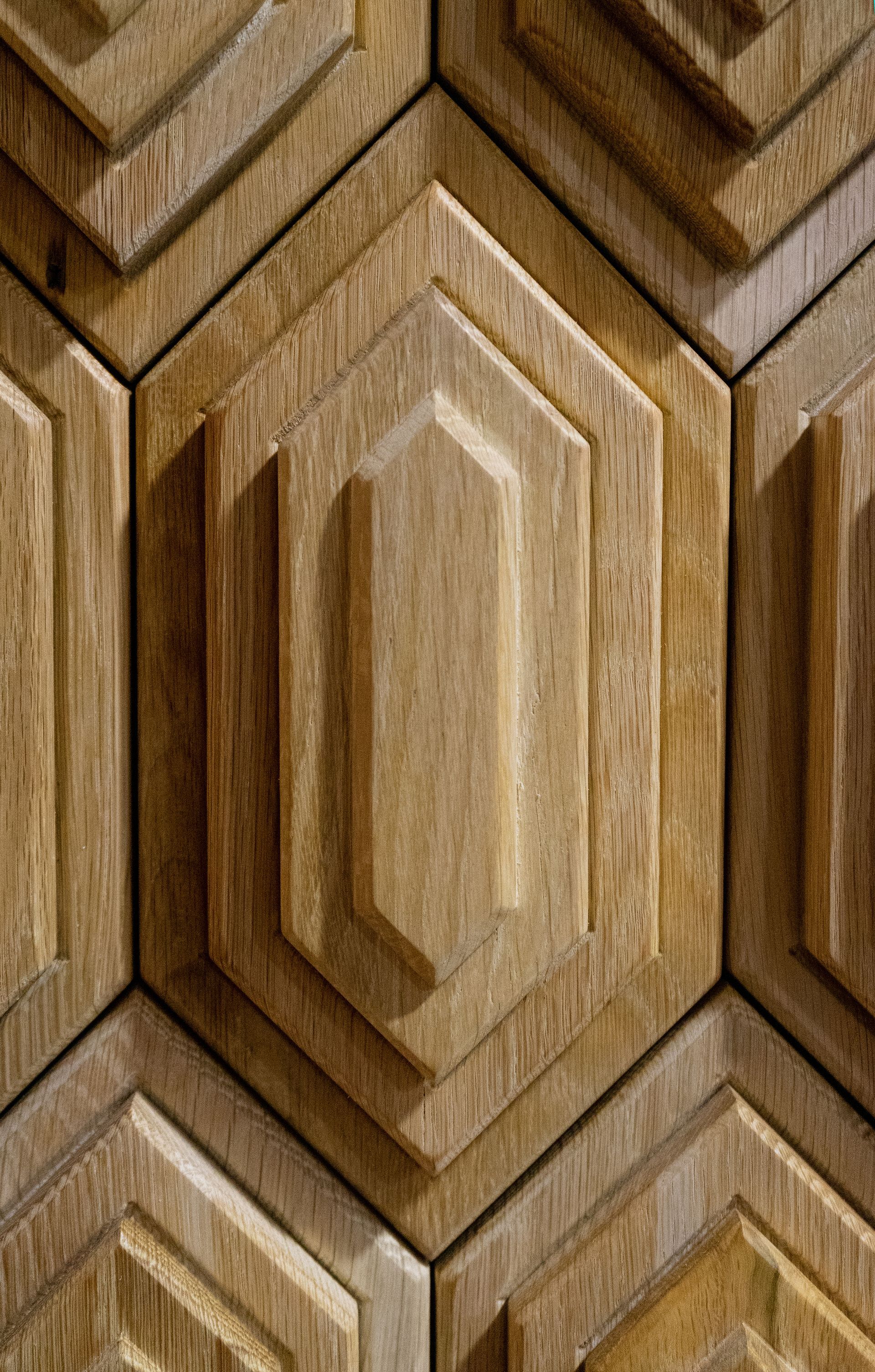 A close up of a wooden wall with a hexagonal pattern.