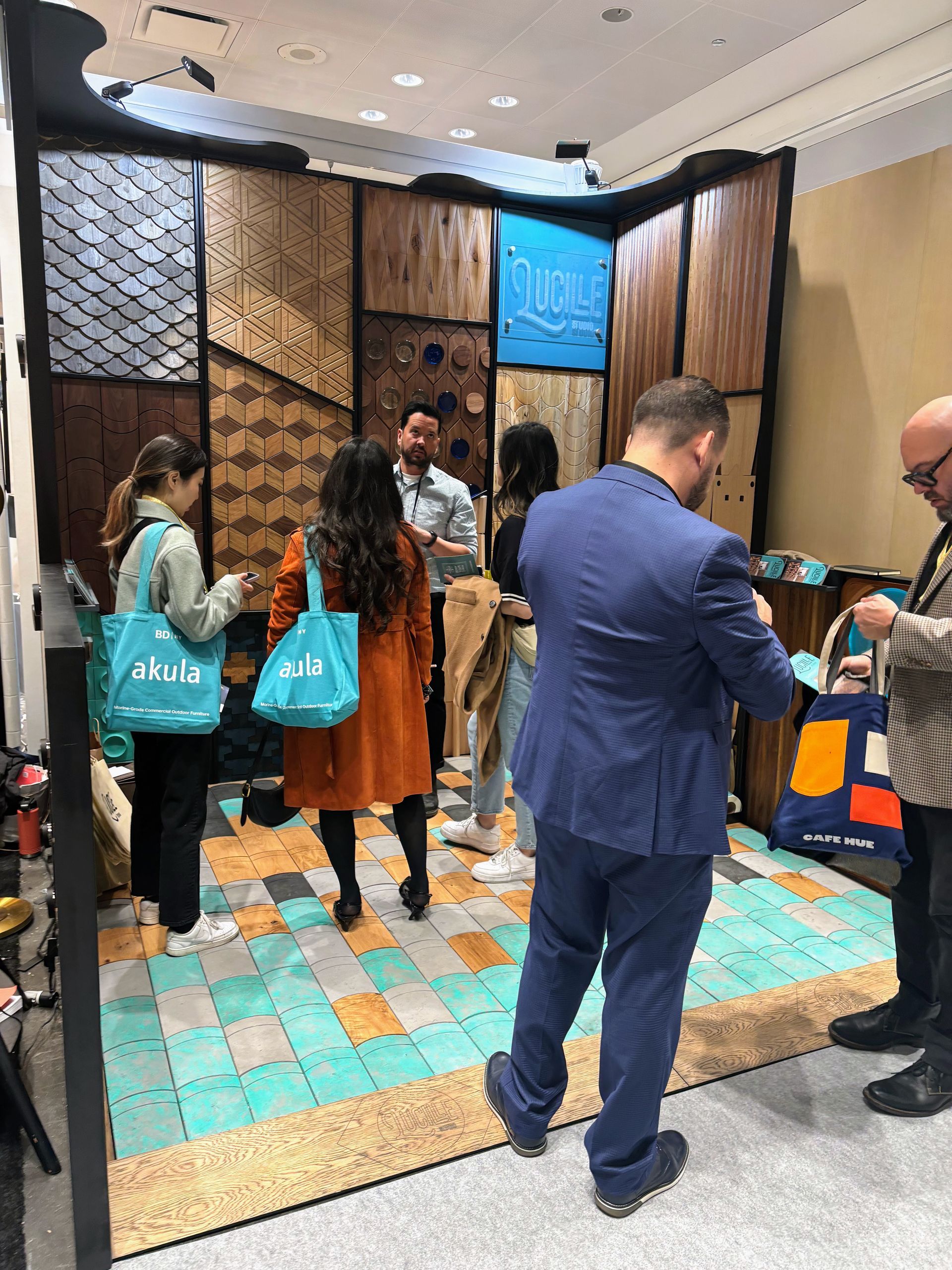 A group of people are standing around a booth at a convention.