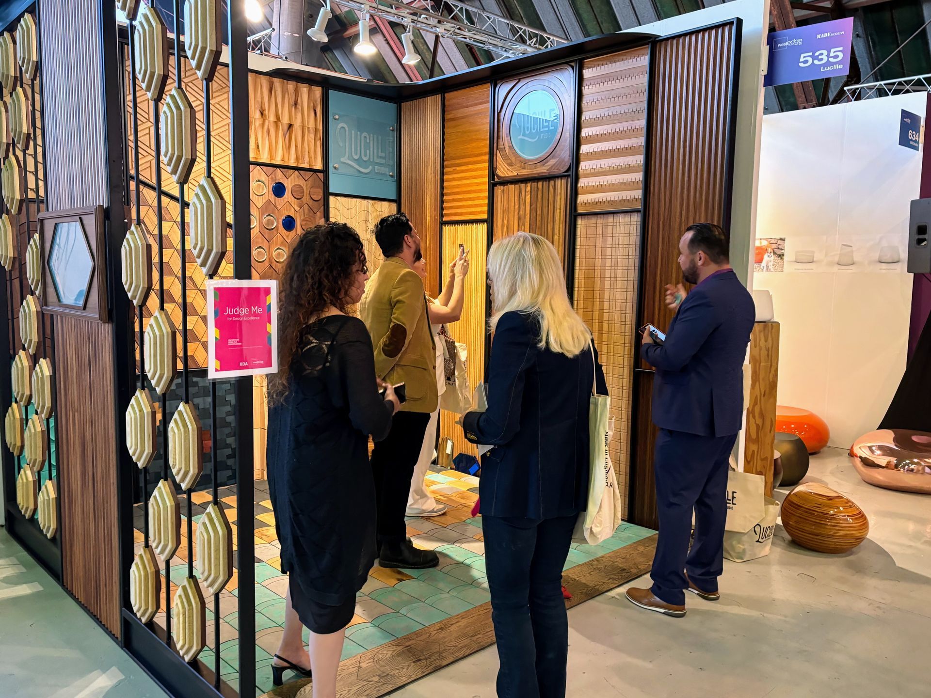 A group of people are standing in front of a wooden wall.
