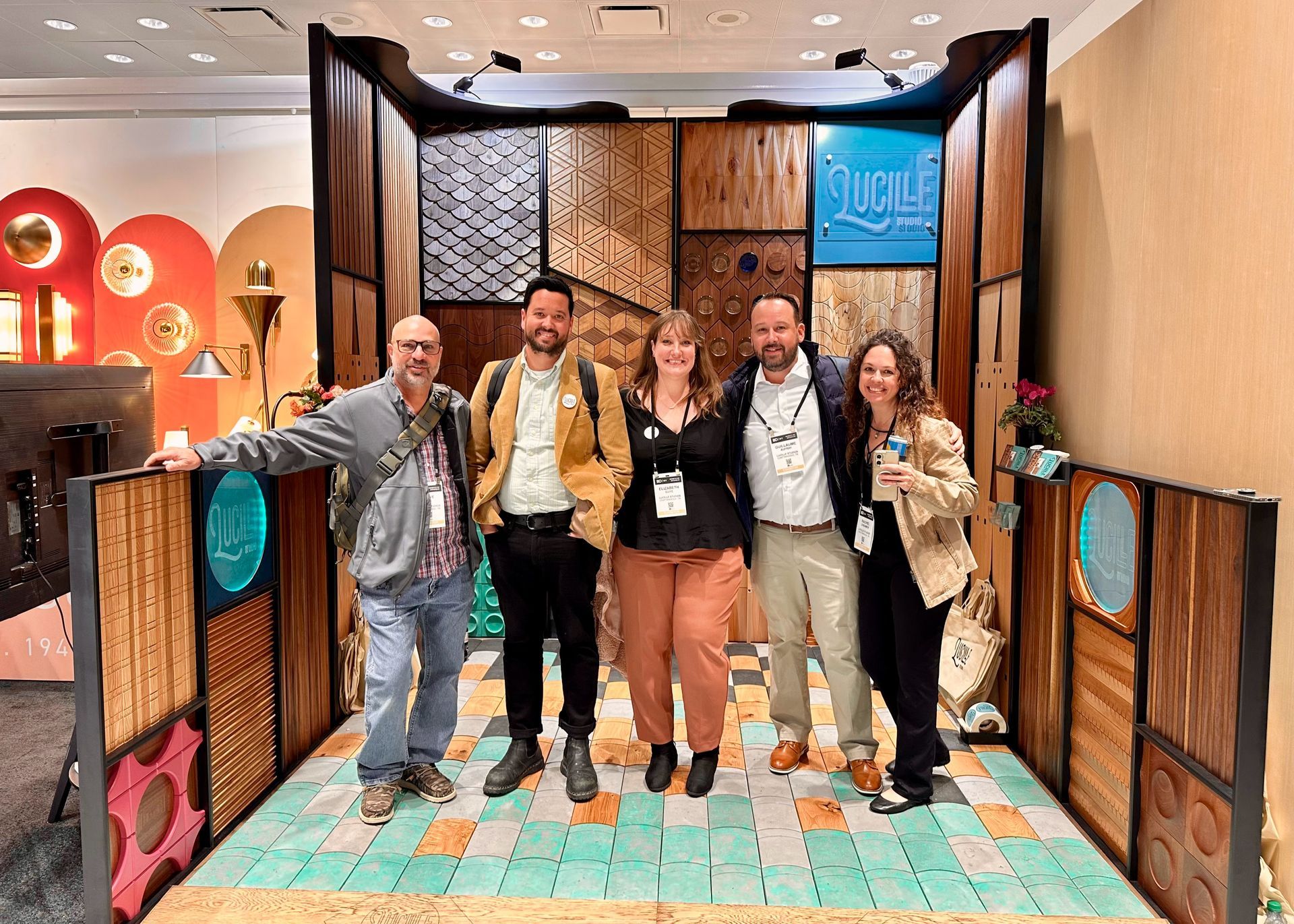 A group of people are posing for a picture in front of a wooden wall.