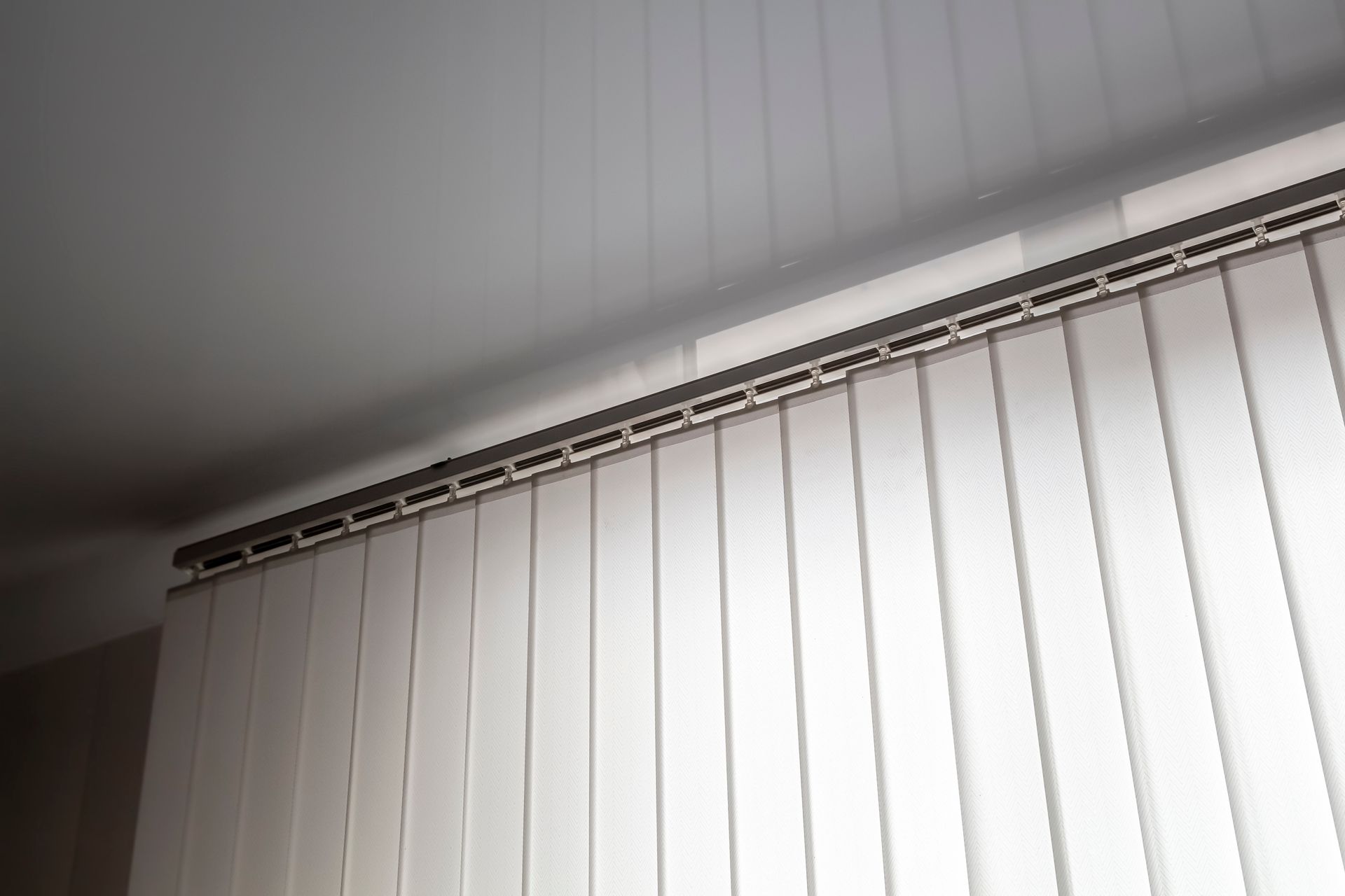 Vertical blinds covering a large window in a living room.