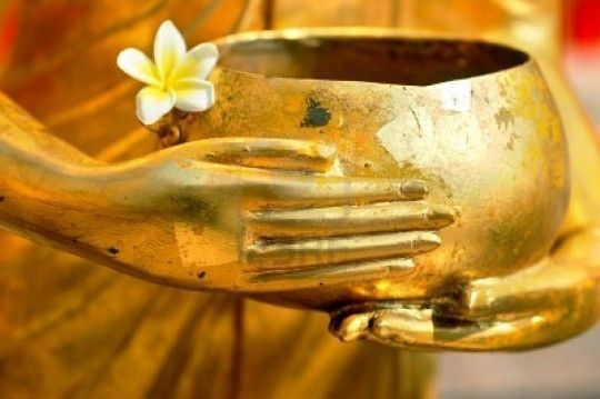 Dana Bowl. Golden statue holding a gold bowl with a white flower in it.