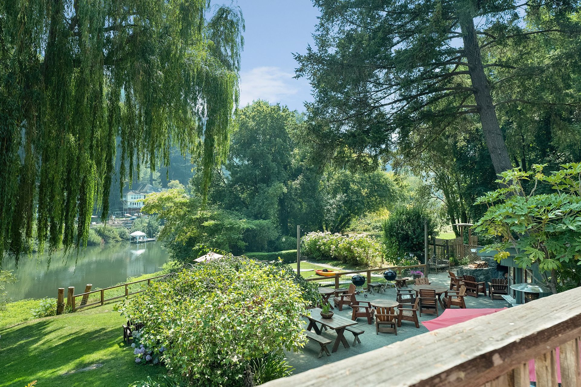 A view of a park with tables and chairs and a river in the background
