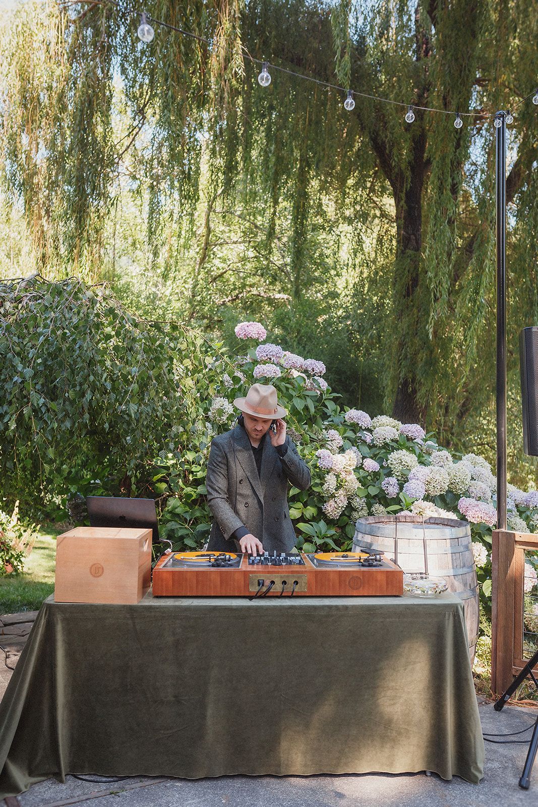 A DJ plays music for a wedding in front of beautiful