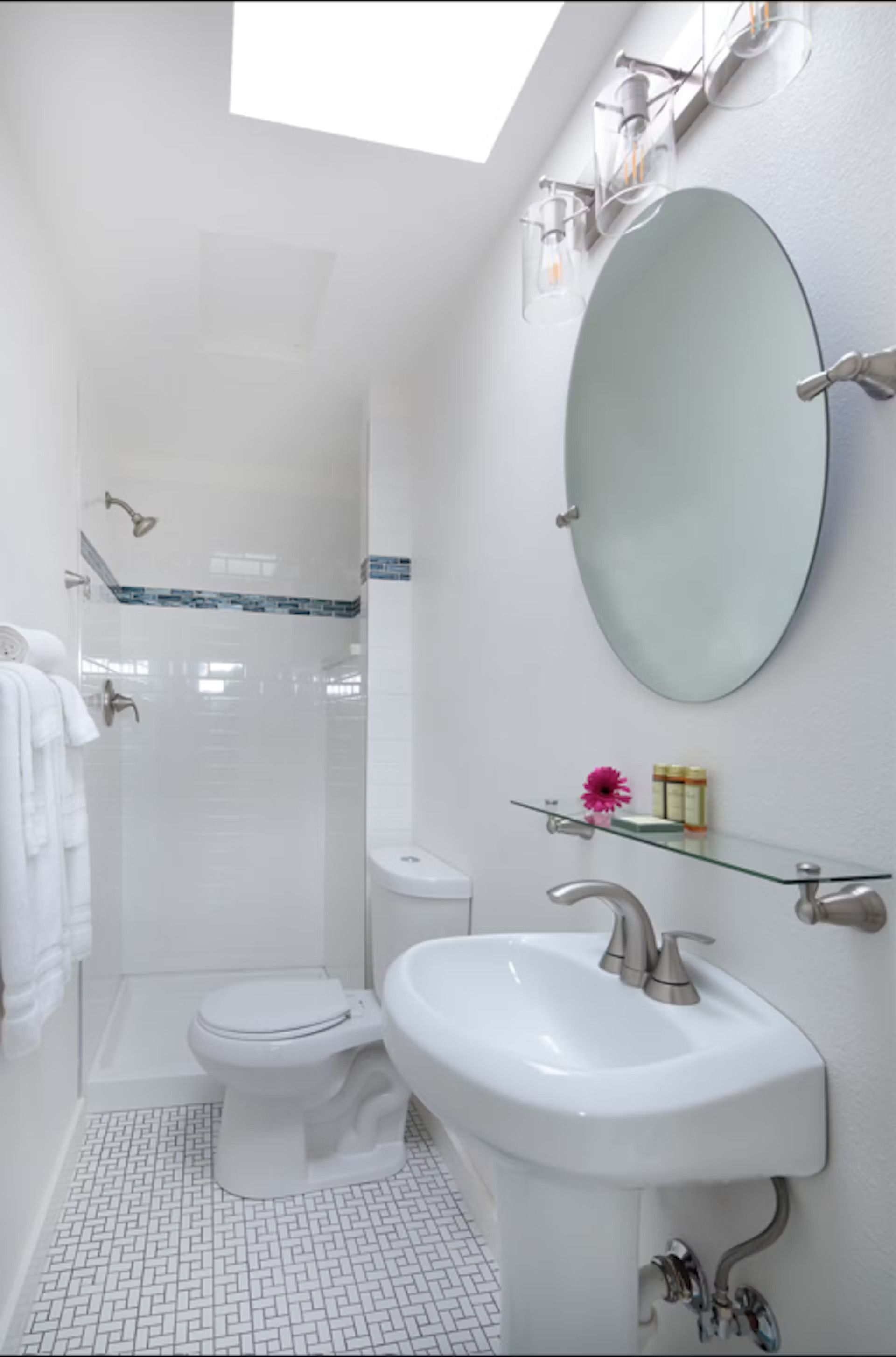 A bathroom with a toilet , sink and mirror