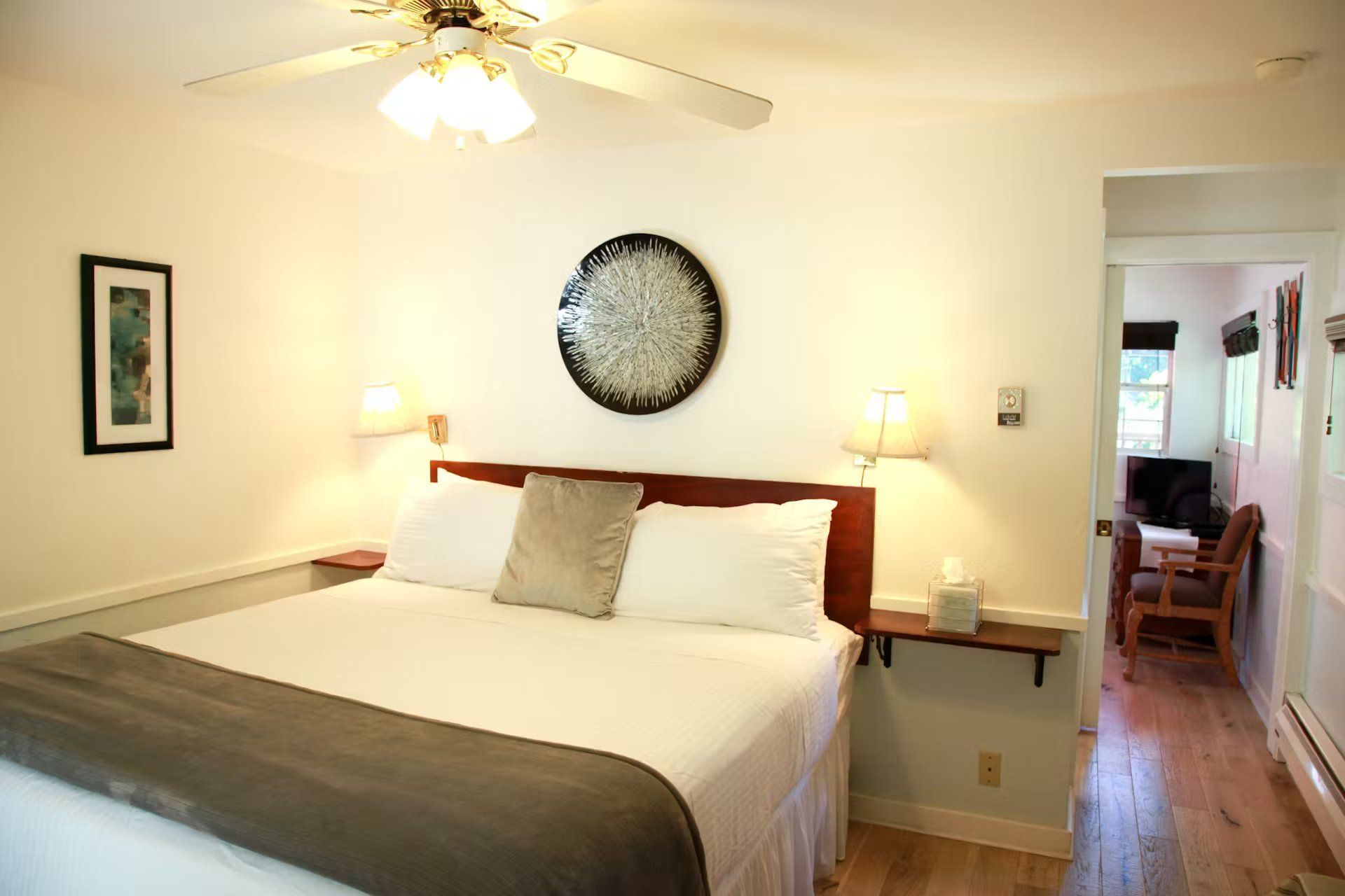 A bedroom with a king size bed and a ceiling fan