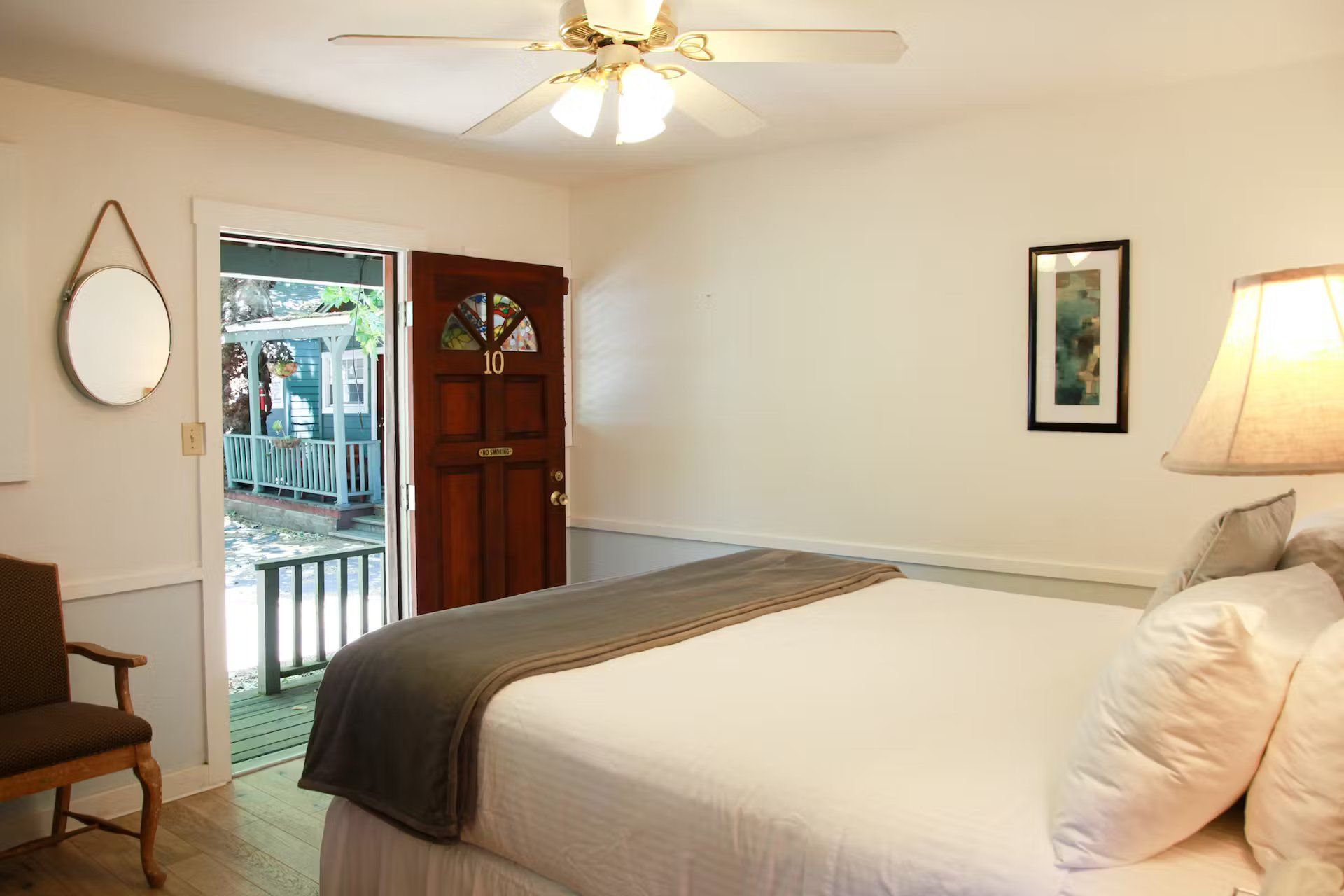 A bedroom with a king size bed and a ceiling fan.