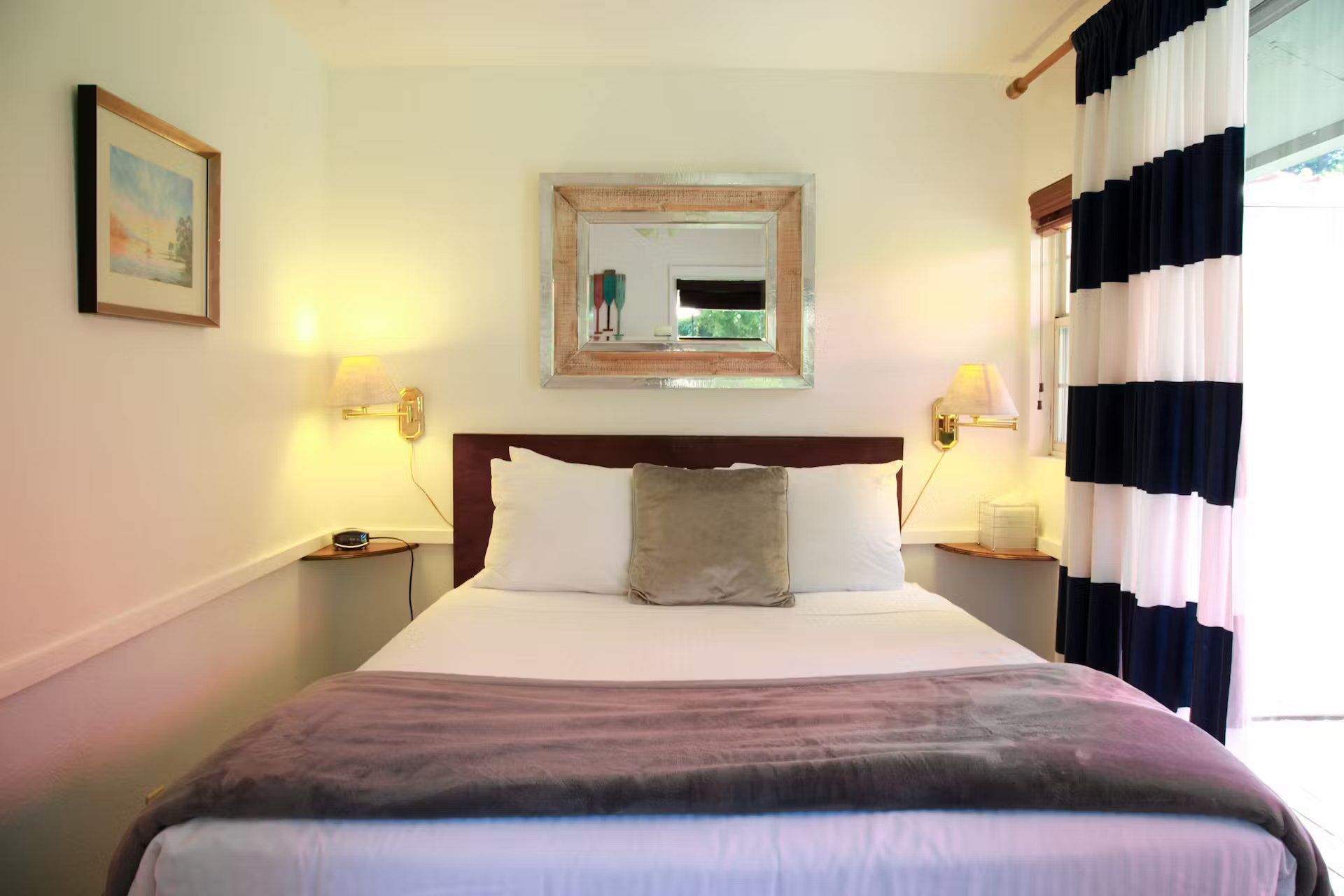 A bedroom with a bed and a mirror on the wall
