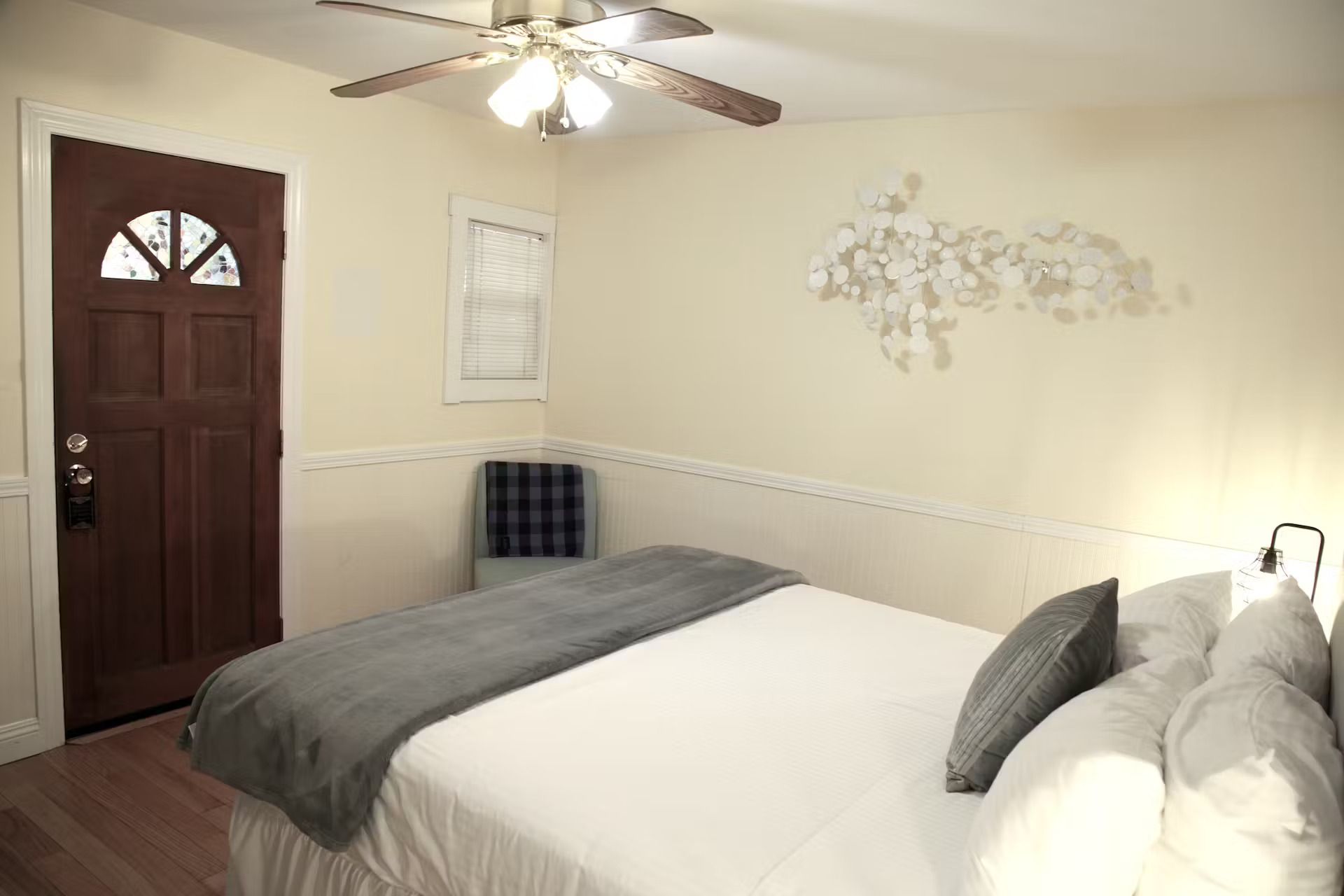 A bedroom with a bed , chair and ceiling fan.