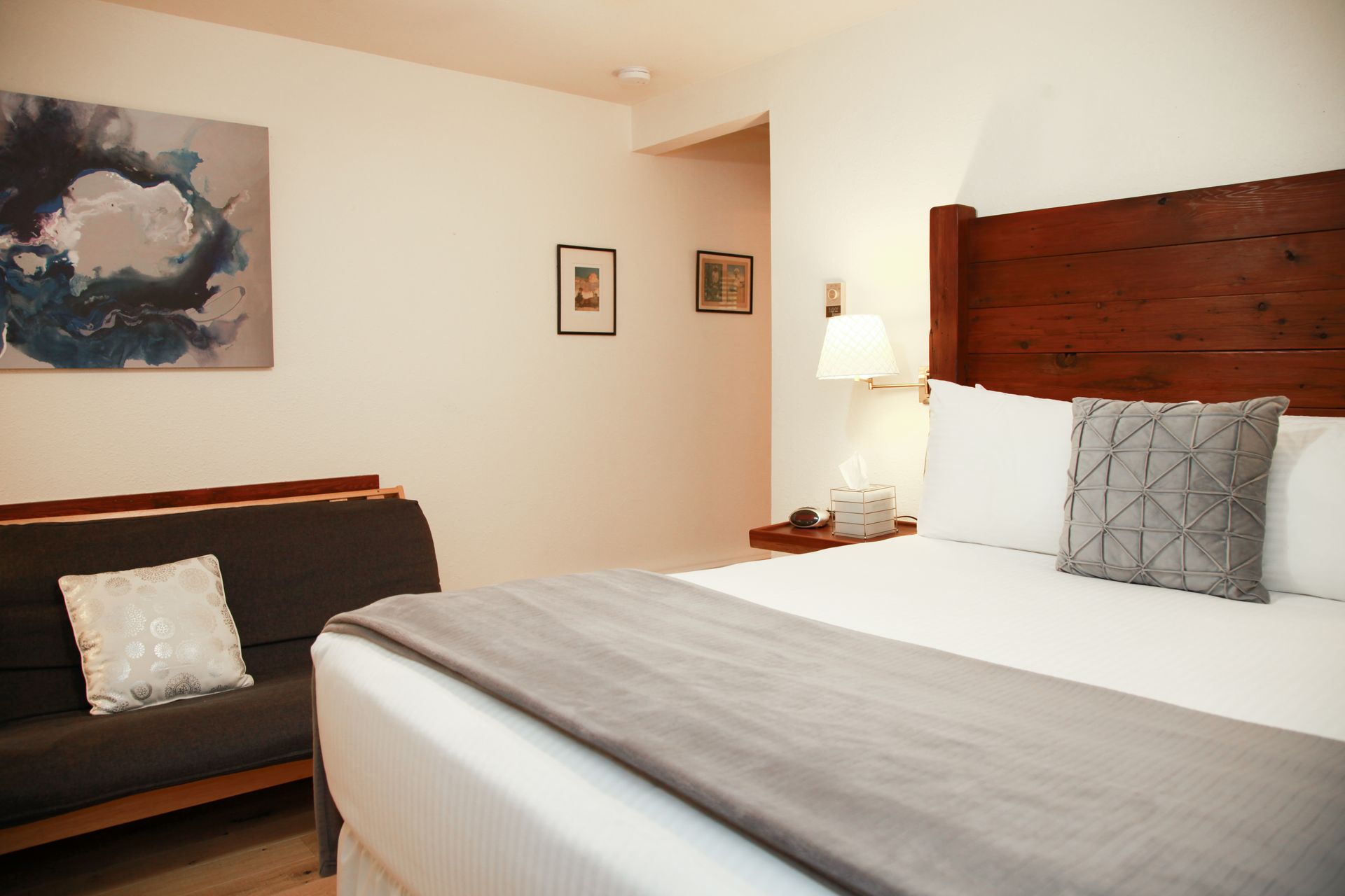 A hotel room with a king size bed and a futon.