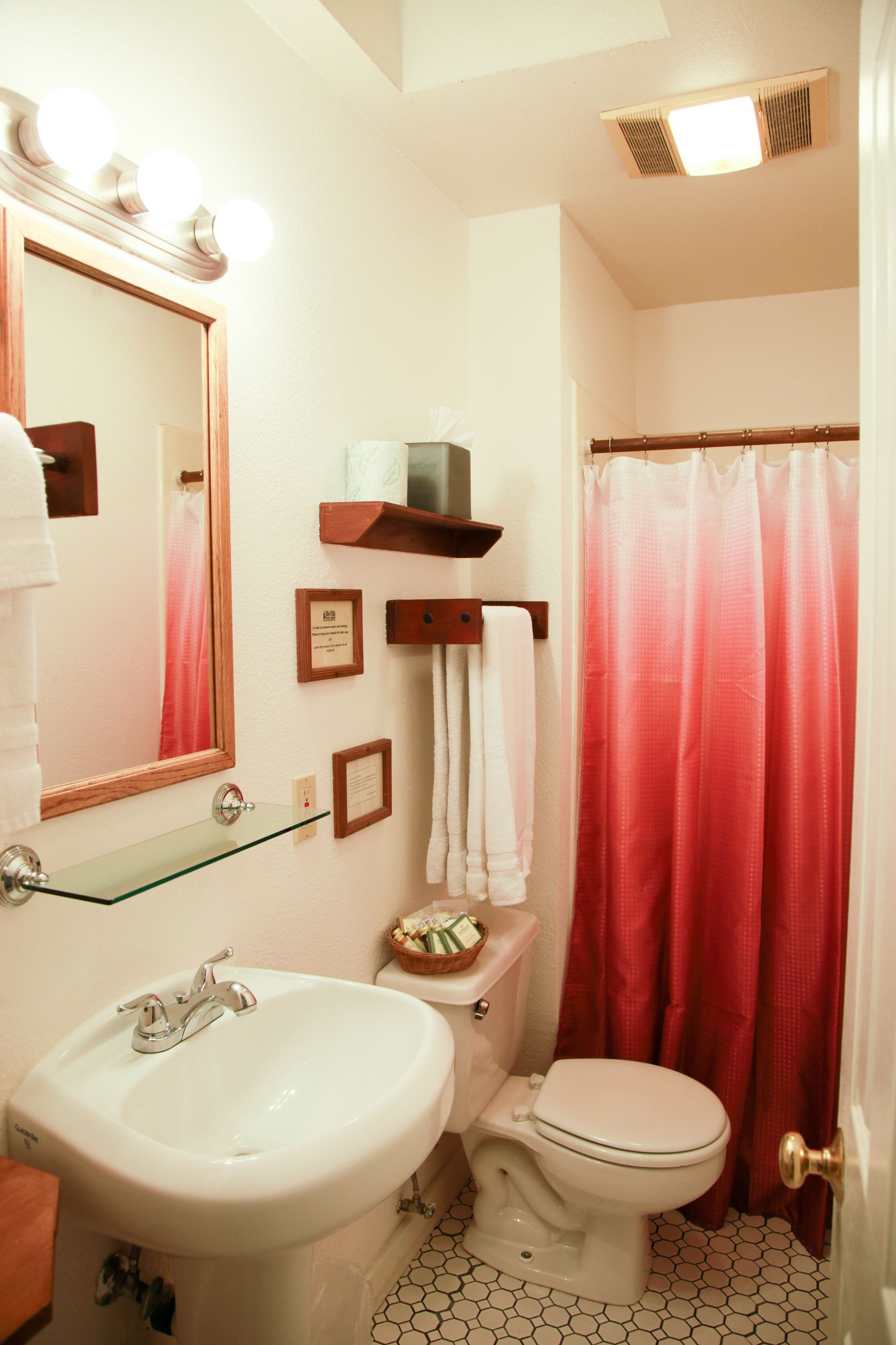 A bathroom with a toilet a sink and a mirror