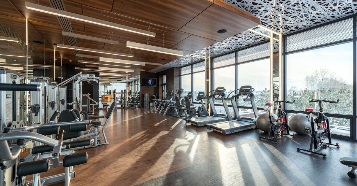 A large gym with a lot of equipment and a lot of windows.
