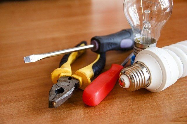 Outils électriques et ampoules sur une surface en bois.
