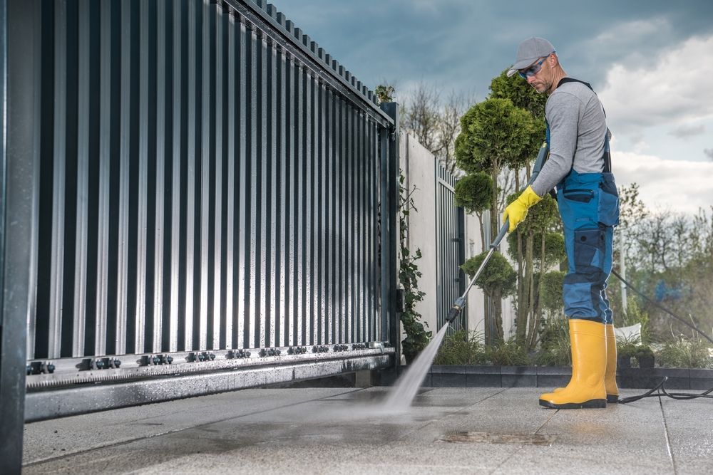 Pressure washing a wooden deck, with a spray nozzle cleaning wet boards
