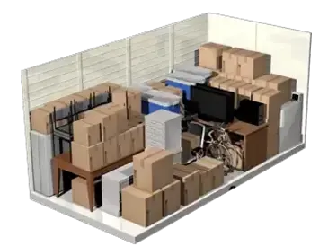 Small warehouse room filled with stacked cardboard boxes, desks, and office equipment in a cluttered storage area