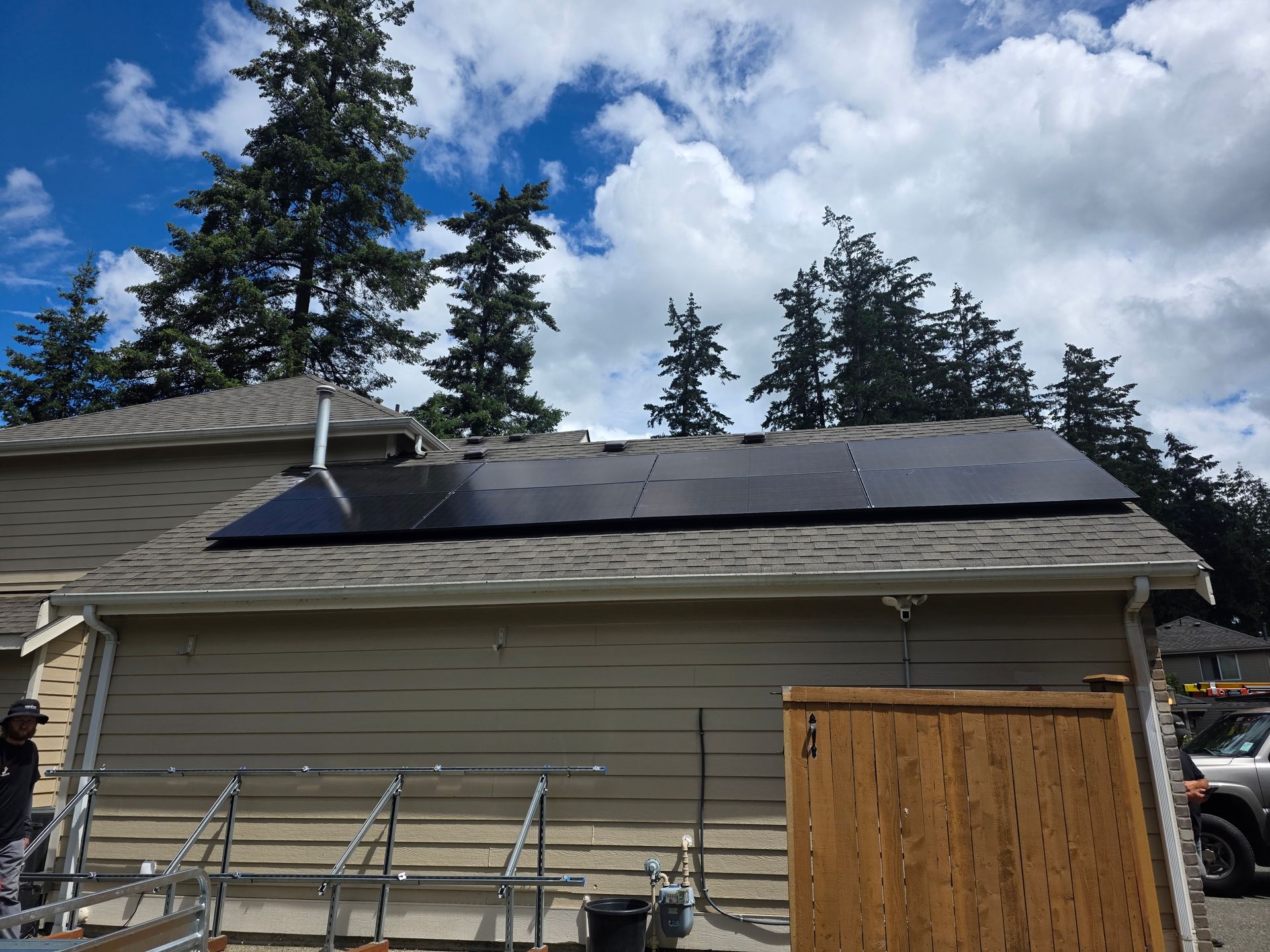 Rooftop solar panels on a large industrial building under a cloudy sky