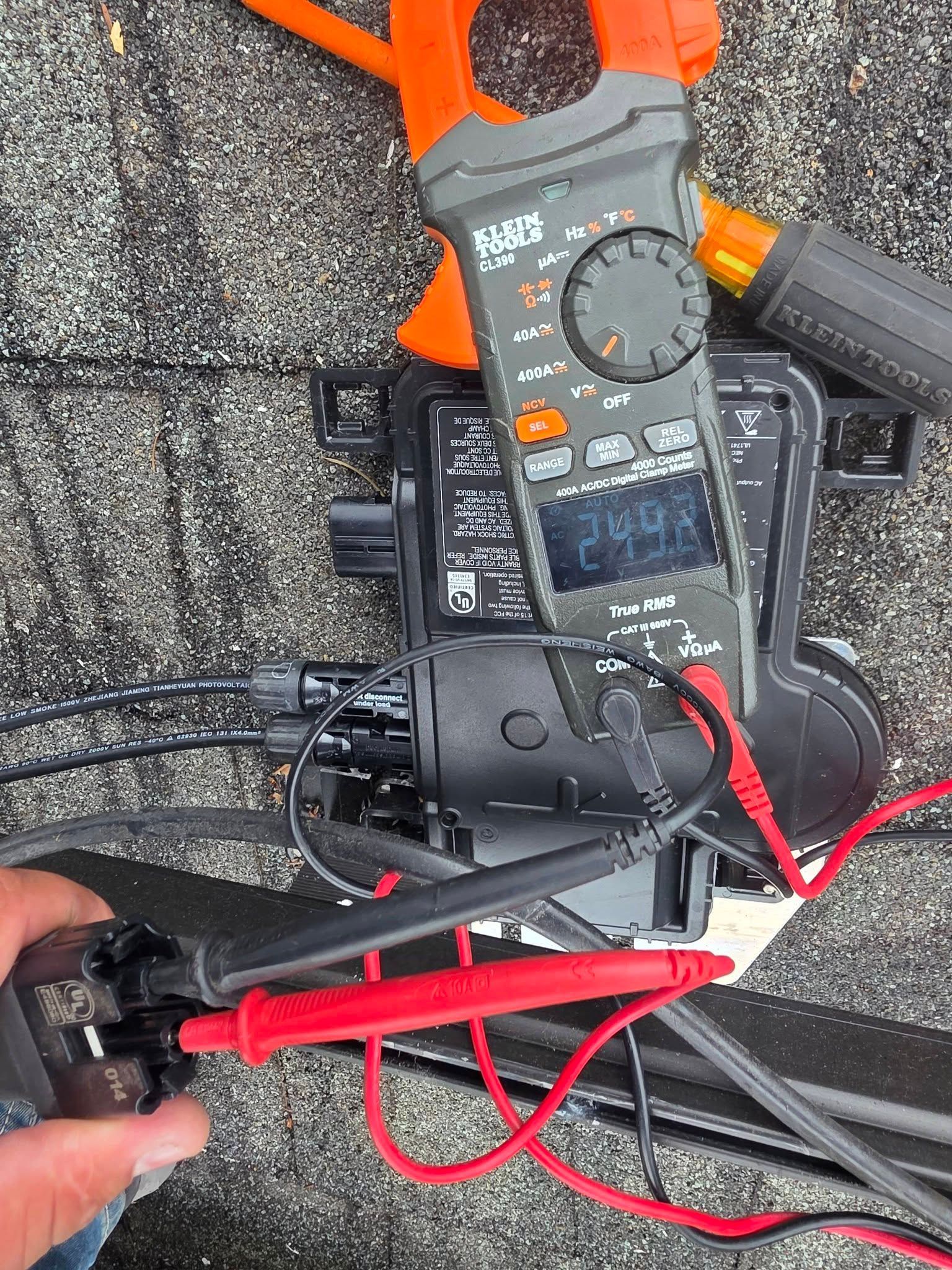 Close-up of a digital multimeter with red and black probes on a gray carpet