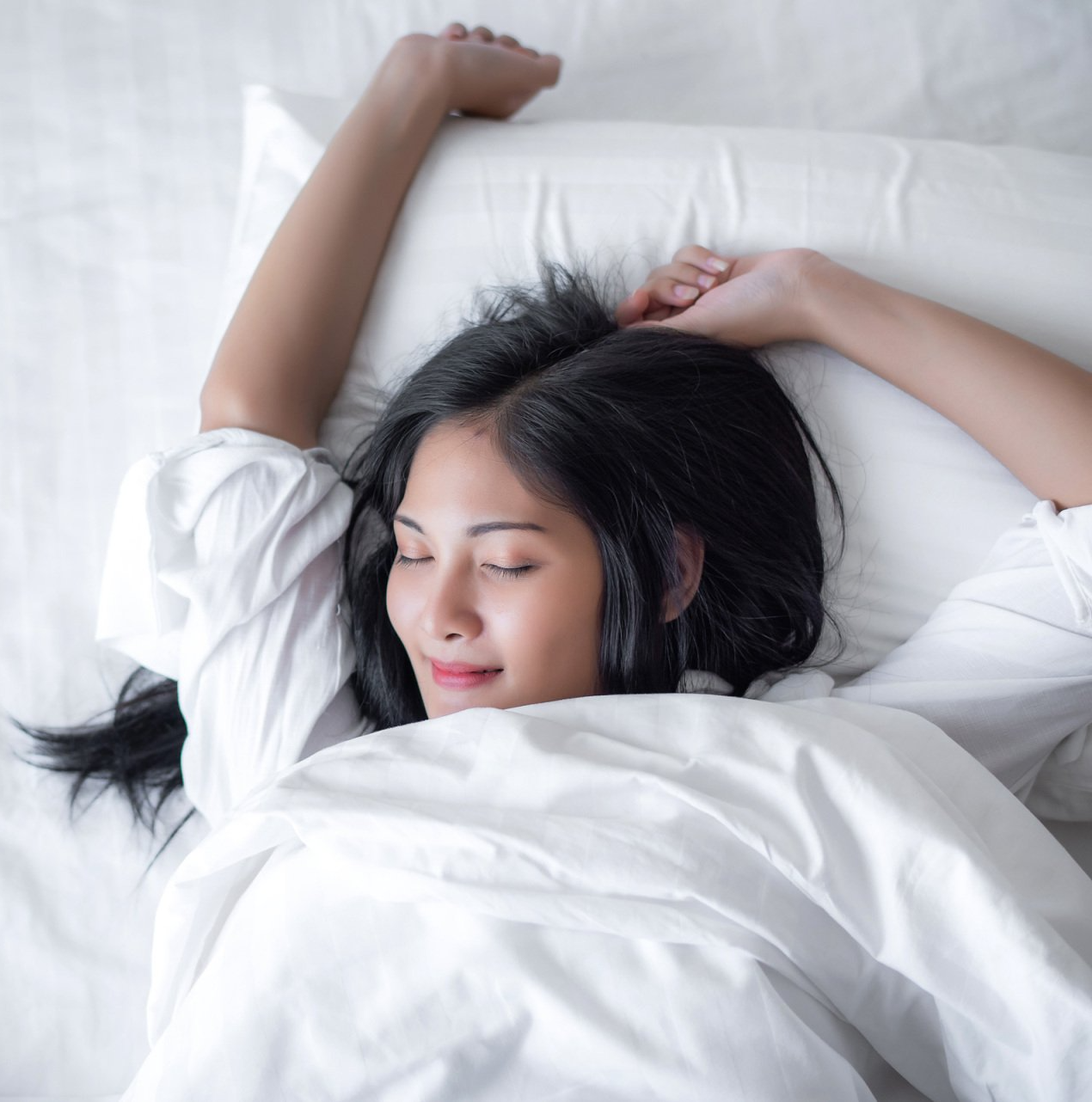 Woman stretching in bed