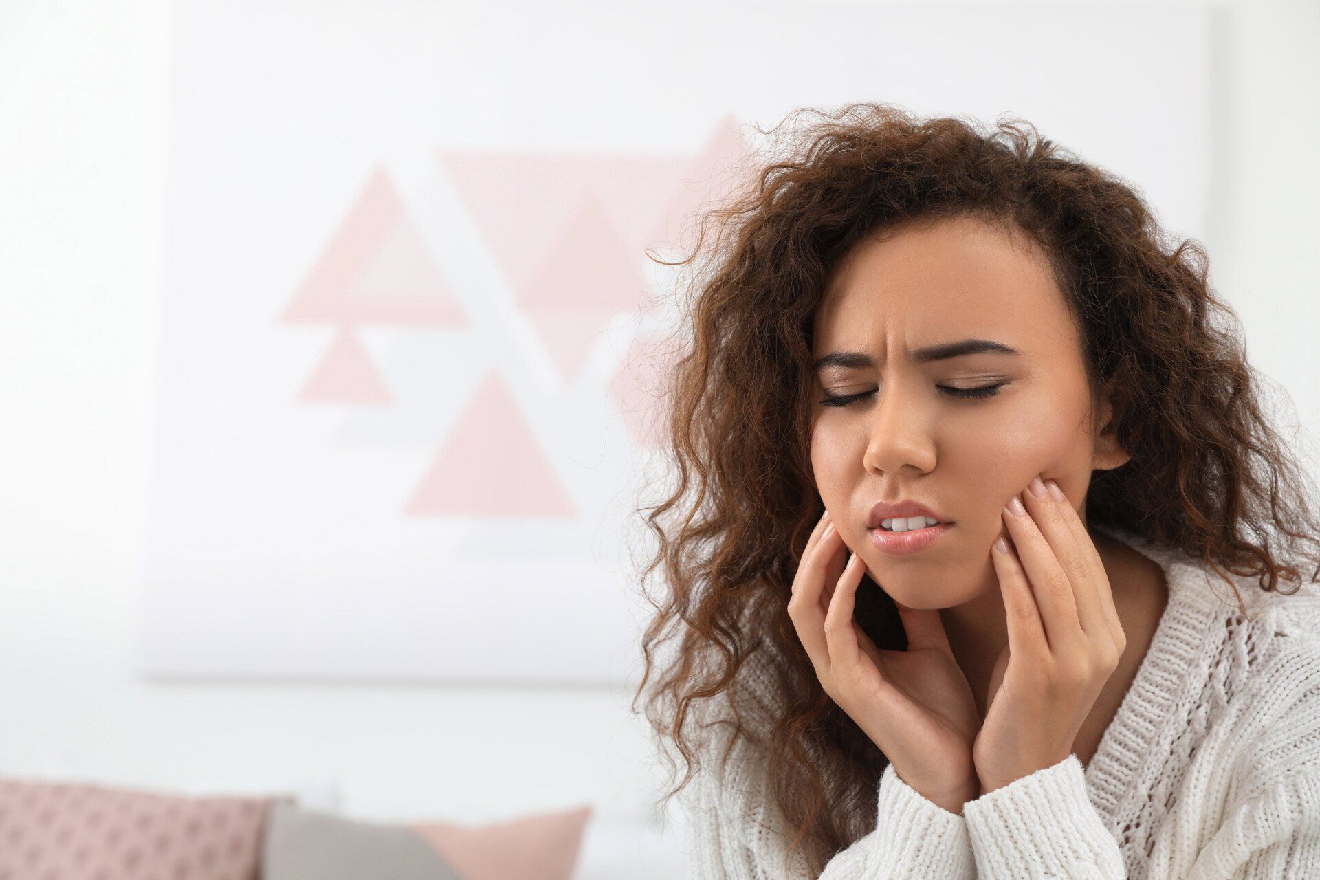 Woman holding jaw in pain